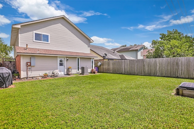 back of property with central air condition unit and a yard