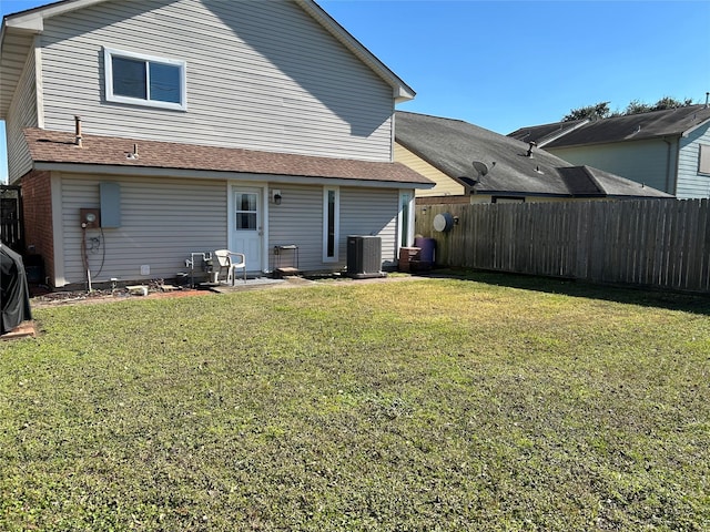 back of house featuring a lawn and central AC