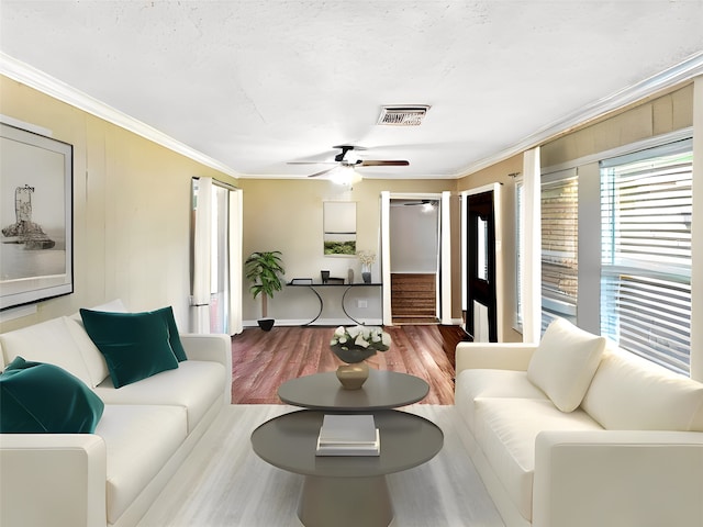 living room featuring hardwood / wood-style floors, ceiling fan, and ornamental molding