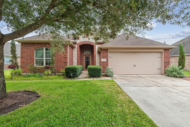 ranch-style house with roof with shingles, concrete driveway, an attached garage, a front yard, and brick siding