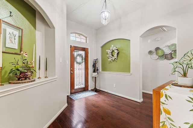 foyer entrance featuring an inviting chandelier, baseboards, and wood-type flooring