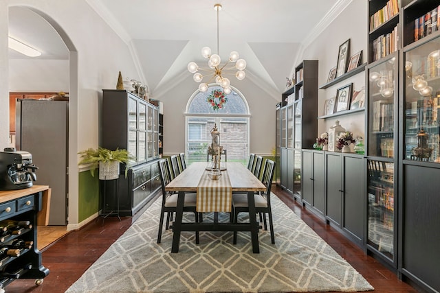 dining space with baseboards, lofted ceiling, arched walkways, ornamental molding, and dark wood-type flooring