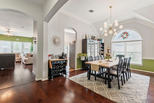 dining room featuring visible vents, vaulted ceiling, ceiling fan with notable chandelier, arched walkways, and wood-type flooring