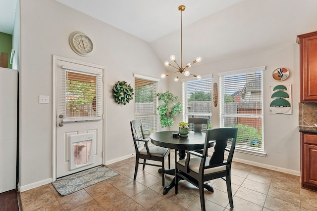 dining room featuring a chandelier, baseboards, and vaulted ceiling