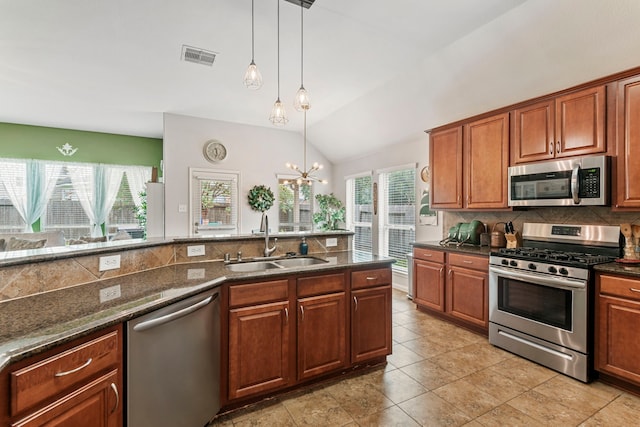 kitchen featuring visible vents, backsplash, decorative light fixtures, appliances with stainless steel finishes, and a sink