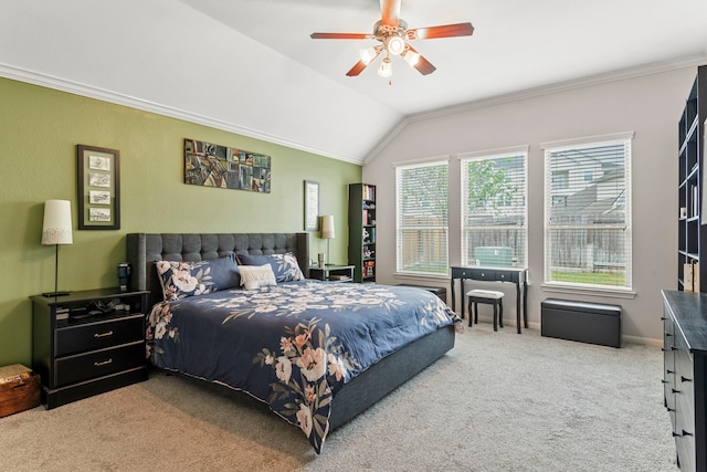 carpeted bedroom with ceiling fan, ornamental molding, and vaulted ceiling