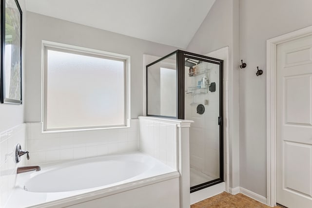 full bathroom featuring lofted ceiling, a stall shower, and a bath