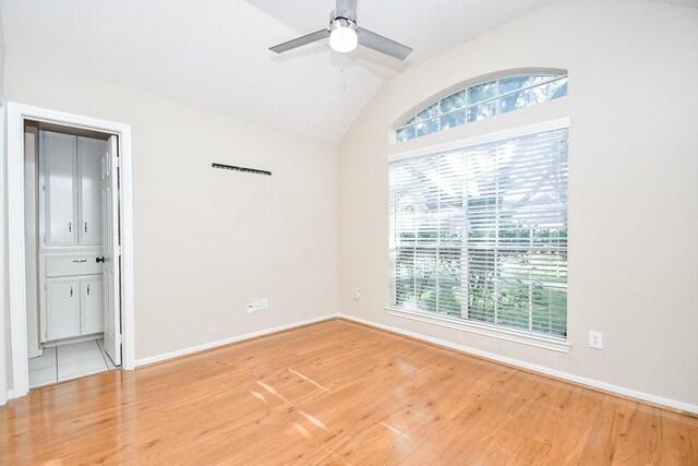 unfurnished room featuring hardwood / wood-style flooring, ceiling fan, and vaulted ceiling