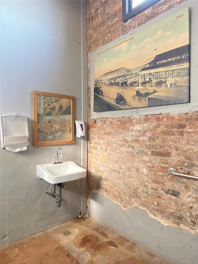2127 Broadway St, Galveston, TX 77550 - bathroom with a sink, brick wall, and concrete floors