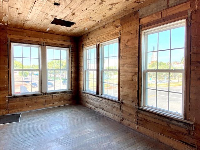 2127 Broadway St, Galveston, TX 77550 - spare room with wood walls, plenty of natural light, wooden ceiling, and wood-type flooring