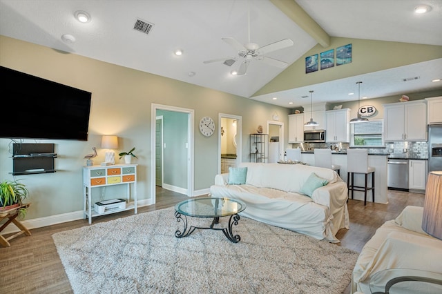 living room featuring light wood-type flooring, ceiling fan, high vaulted ceiling, and beamed ceiling