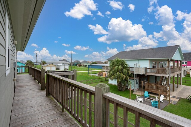 wooden terrace with an outbuilding, a yard, and a patio