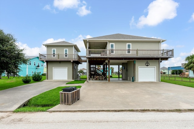 coastal home with a garage, a carport, a balcony, and a front yard