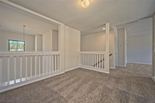 spare room featuring carpet and a textured ceiling