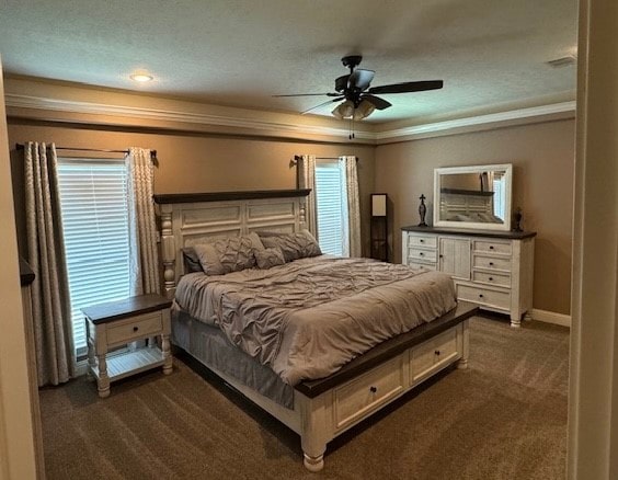 carpeted bedroom with a textured ceiling, crown molding, and ceiling fan