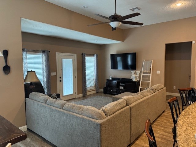 living room featuring a healthy amount of sunlight, ceiling fan, and hardwood / wood-style flooring