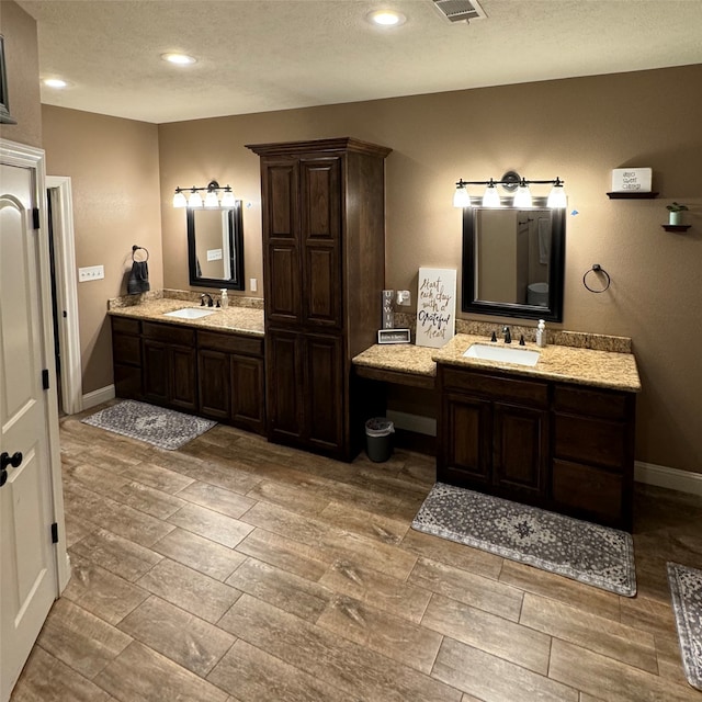 bathroom with vanity, a textured ceiling, and hardwood / wood-style floors