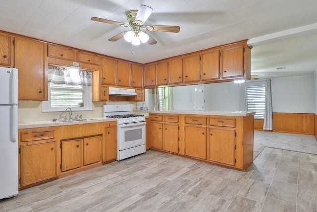 kitchen with white appliances, sink, kitchen peninsula, and ceiling fan