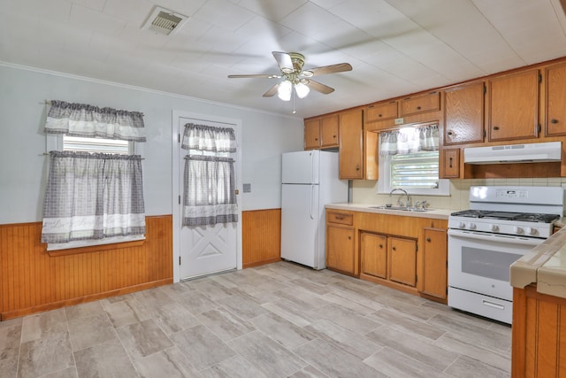 kitchen featuring white appliances, tile counters, ornamental molding, sink, and ceiling fan