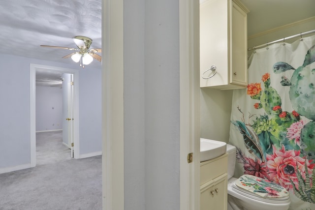 bathroom with vanity, toilet, curtained shower, and ceiling fan