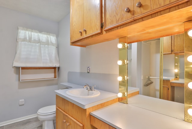 bathroom featuring vanity, toilet, and hardwood / wood-style flooring