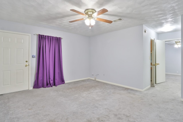 empty room with a textured ceiling, carpet flooring, and ceiling fan