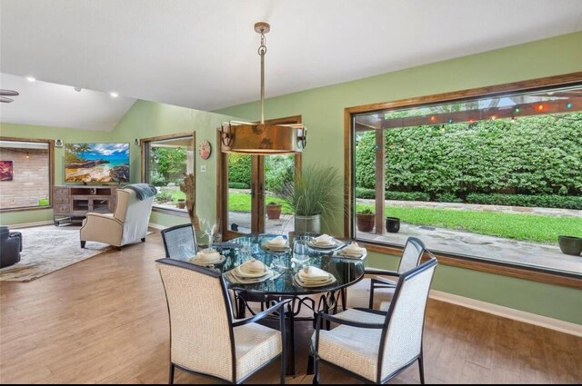 dining area with lofted ceiling and hardwood / wood-style floors