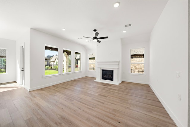 unfurnished living room featuring plenty of natural light, ceiling fan, and light wood-type flooring