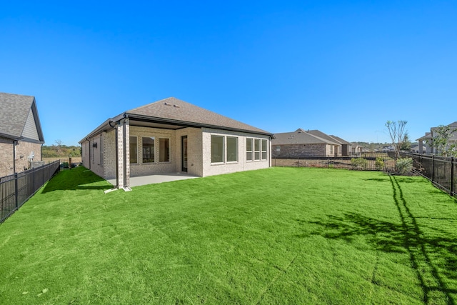 rear view of property with a yard and a patio