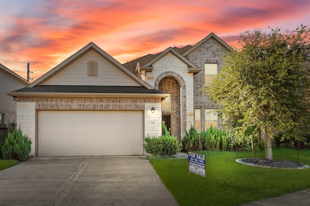 view of front of house featuring a garage and a lawn