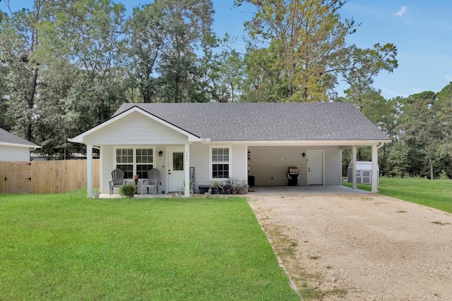 ranch-style home featuring covered porch, a carport, and a front lawn