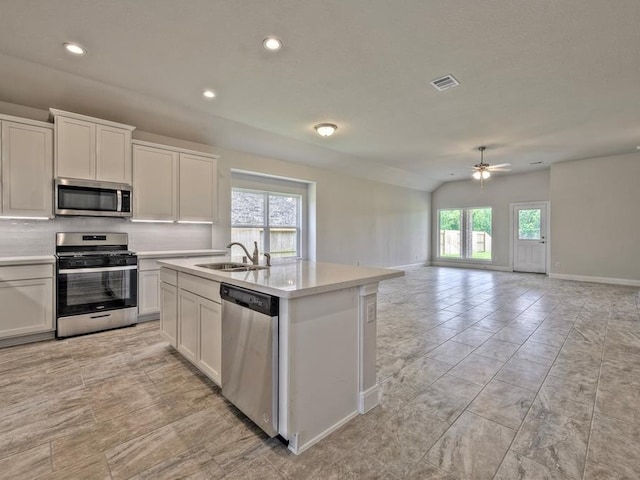 kitchen with appliances with stainless steel finishes, white cabinetry, and a wealth of natural light