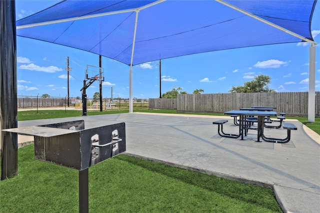 view of property's community with basketball court and a lawn