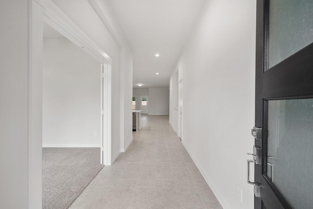 hall with light colored carpet