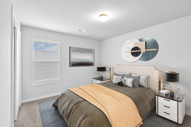 bedroom with dark colored carpet, visible vents, and baseboards