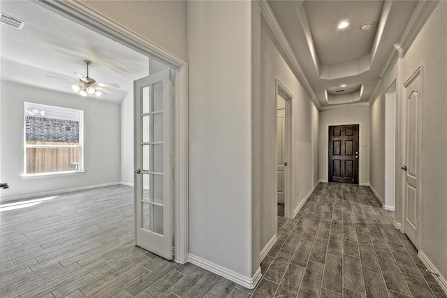 hall with dark wood-type flooring and a tray ceiling