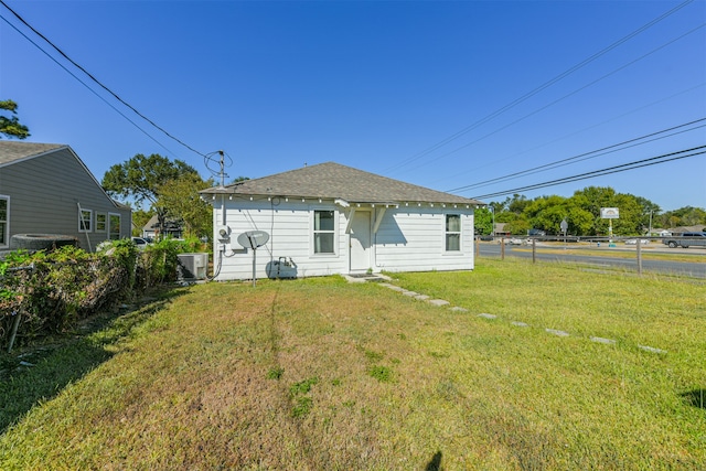 back of property featuring cooling unit and a lawn