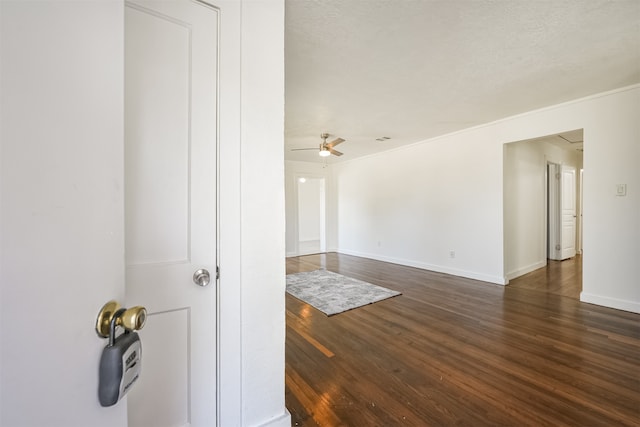 unfurnished room with ornamental molding, a textured ceiling, dark hardwood / wood-style floors, and ceiling fan