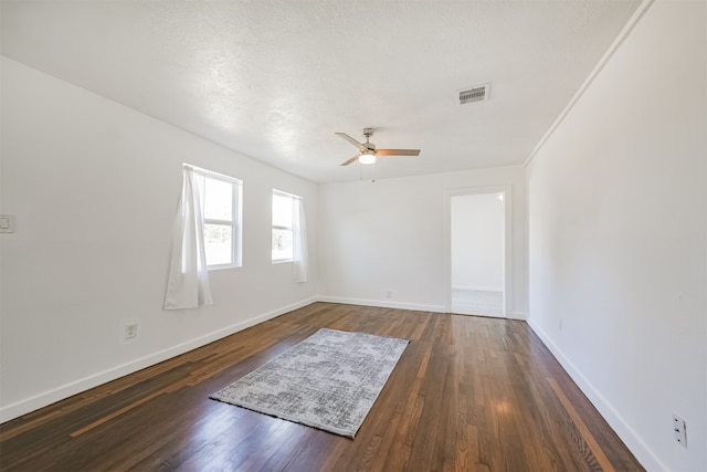 unfurnished room with a textured ceiling, ceiling fan, and dark hardwood / wood-style flooring