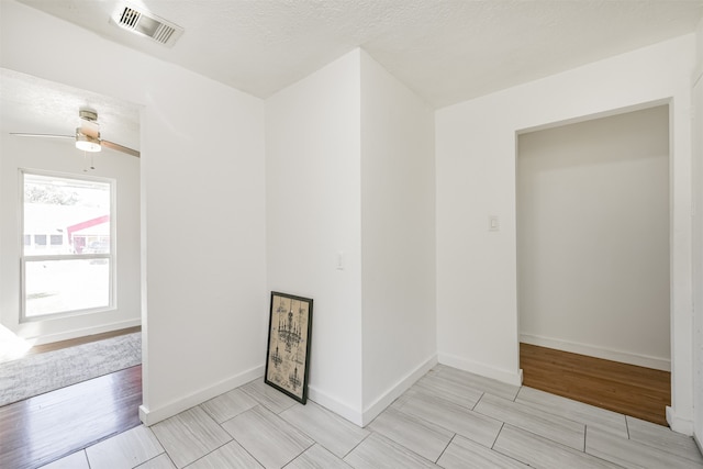 spare room with ceiling fan and a textured ceiling