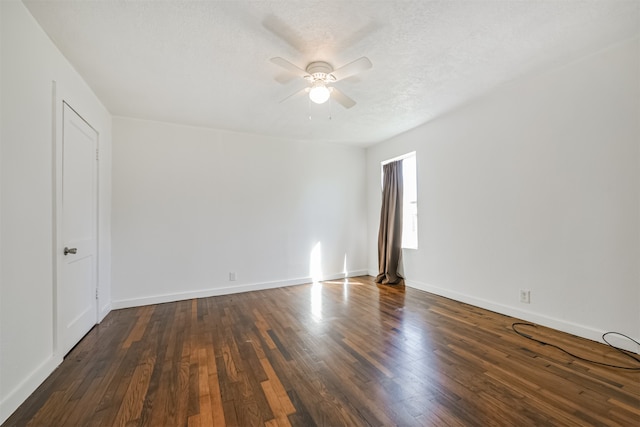 empty room featuring a textured ceiling, dark wood-type flooring, and ceiling fan