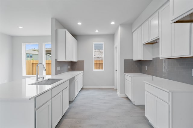 kitchen featuring white cabinets, a wealth of natural light, and sink