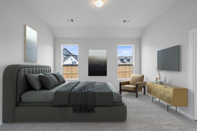 carpeted bedroom with lofted ceiling and multiple windows