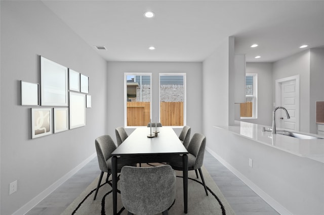 dining area with sink and light hardwood / wood-style flooring