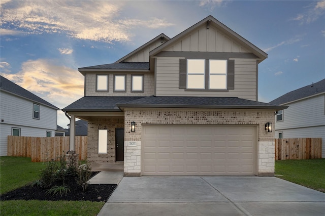 view of front facade featuring a garage, concrete driveway, fence, board and batten siding, and brick siding