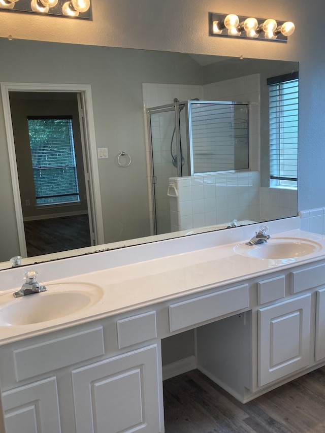 bathroom with wood-type flooring, vanity, and an enclosed shower