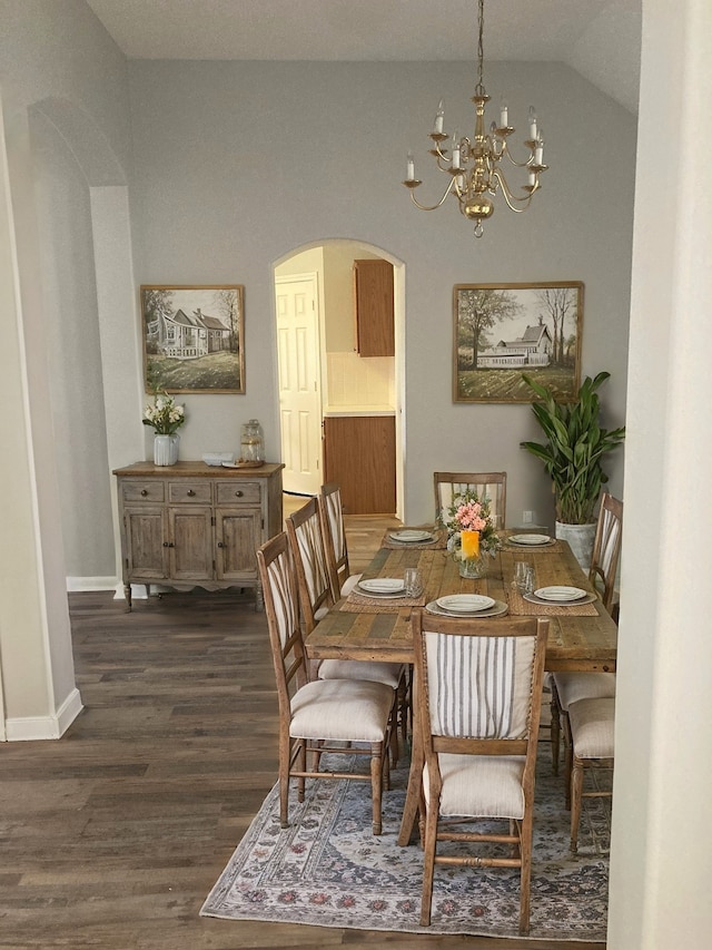 dining room featuring a notable chandelier, vaulted ceiling, and dark wood-type flooring