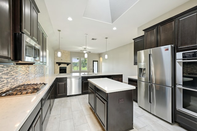 kitchen with sink, hanging light fixtures, kitchen peninsula, stainless steel appliances, and backsplash