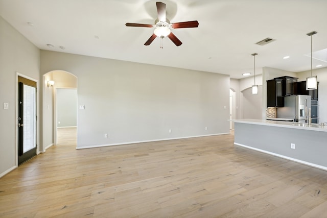 unfurnished living room featuring ceiling fan and light wood-type flooring