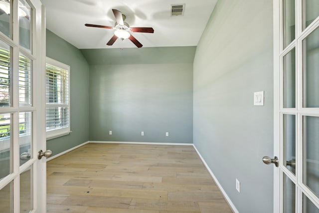 unfurnished room with vaulted ceiling, french doors, ceiling fan, and light wood-type flooring